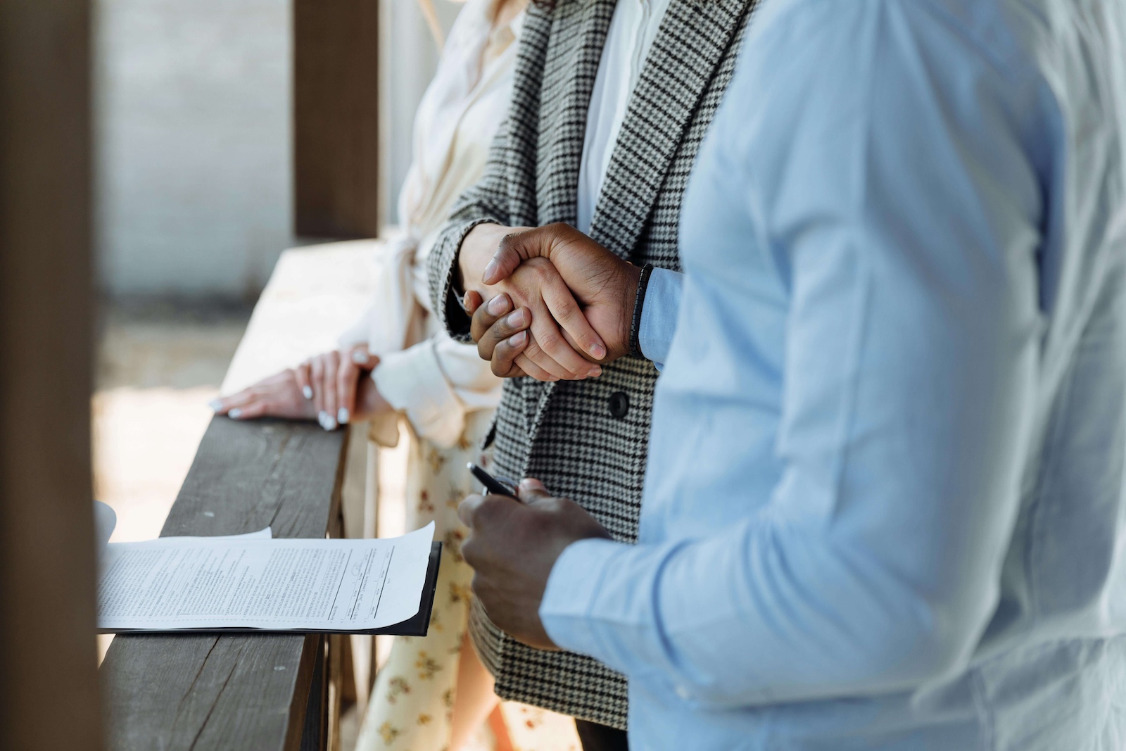People shaking hands across a table with paperwork